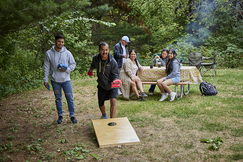 A family playing bean bags at a county park. 
