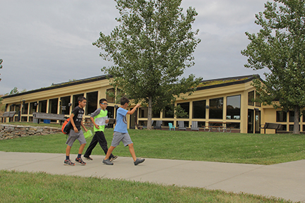 Three boys walking in front of Lebanon Hills Visitor Center.