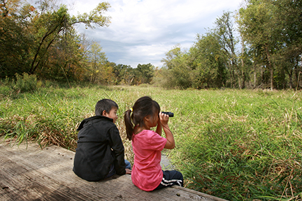 Two kids using binoculars at Miesville Ravine Park Reserve.
